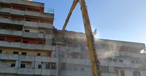 Escavatori a tenaglia impegnati nell'abbattimento della Vela Rossa a Scampia.